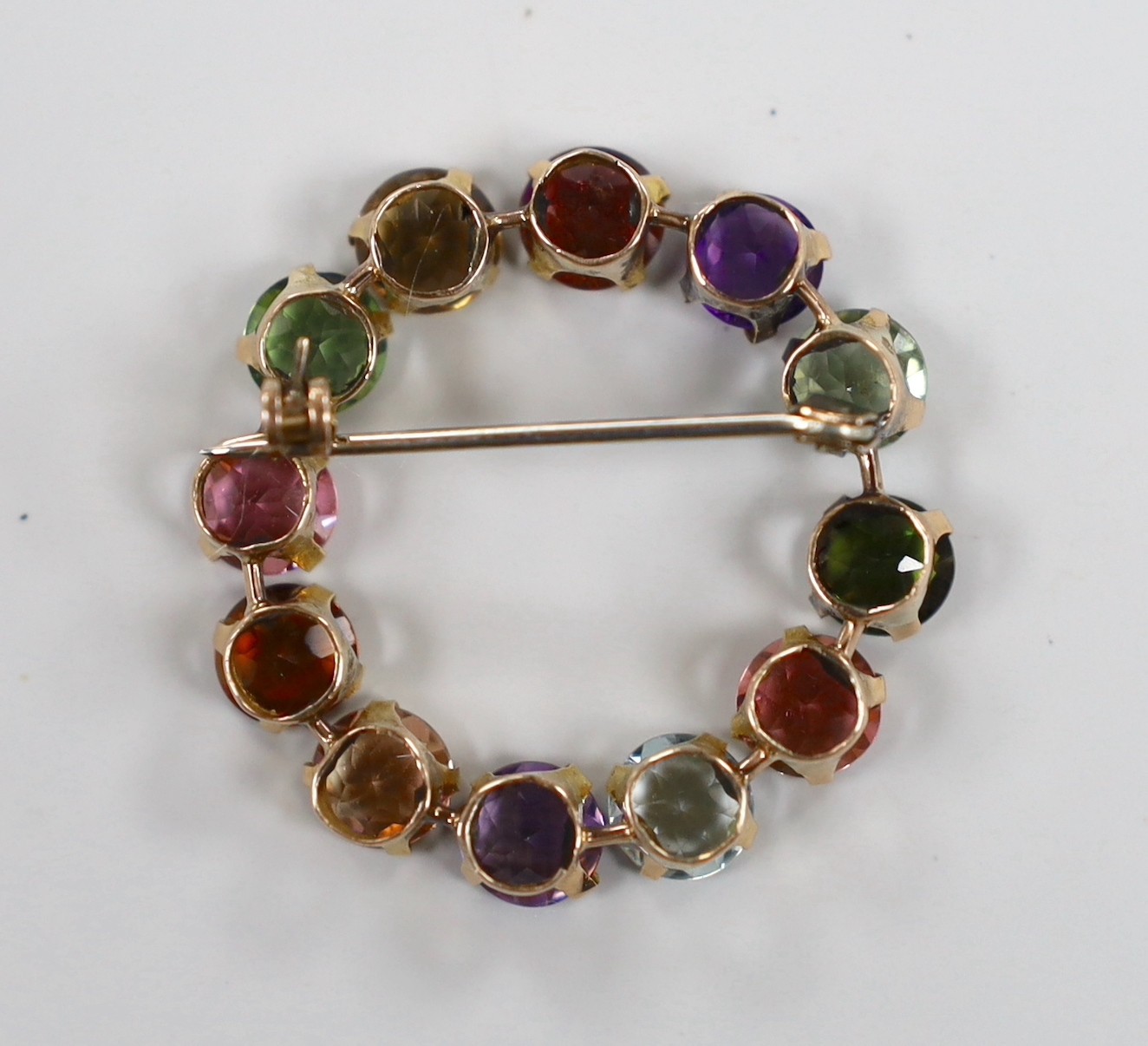 A yellow metal and multi gem set openwork circular brooch, 32mm, gross weight 5 grams.
